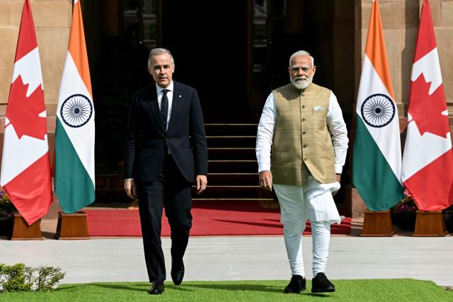 India's Prime Minister Narendra Modi (R) walks with his Canadian counterpart Mark Carney before their meeting at the Hyderabad House in New Delhi on March 2, 2026. (Photo by Sajjad HUSSAIN / AFP)