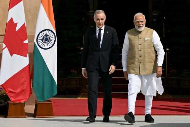 India's Prime Minister Narendra Modi (R) walks with his Canadian counterpart Mark Carney before their meeting at the Hyderabad House in New Delhi on March 2, 2026. (Photo by Sajjad HUSSAIN / AFP)