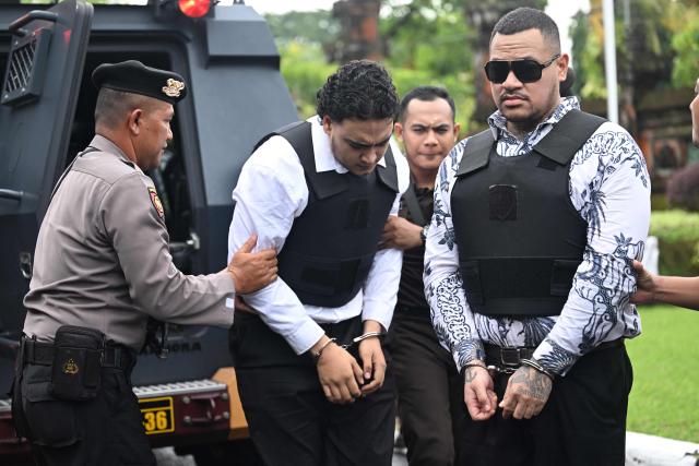 Australian suspects Tupou Pasa Midolmore (C) and Mevlut Coskun (R) are escorted to their trial at a courtroom in Denpasar, Indonesia's Bali island, on March 2, 2026. The trial of three Australians accused of plotting the murder of a compatriot at a villa in Bali continues, with all facing the death penalty. (Photo by SONNY TUMBELAKA / AFP)
