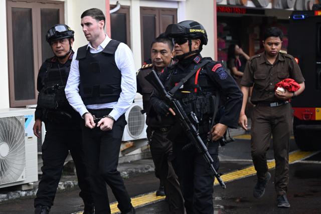 Australian suspect Darcy Francesco Jenson is escorted to his trial at a courtroom in Denpasar, Indonesia's Bali island, on March 2, 2026. The trial of three Australians accused of plotting the murder of a compatriot at a villa in Bali continues, with all facing the death penalty. (Photo by SONNY TUMBELAKA / AFP)
