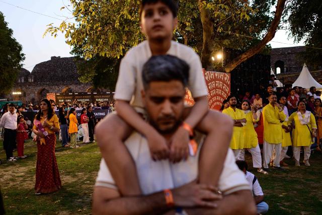 Revellers enjoy Hindu spiritual songs called 'Bhajans' during the Sanatan Journey devotional music festival at the iconic Purana Qila in New Delhi on March 1, 2026. 'Bhajan clubbing' and devotional music festivals are emerging as a new cultural wave in India, mixing traditional spiritual songs with the energy of live concerts. Growing in popularity among young Indians, the trend is reshaping how Gen Z experiences faith and modern spirituality. (Photo by Manan VATSYAYANA / AFP)