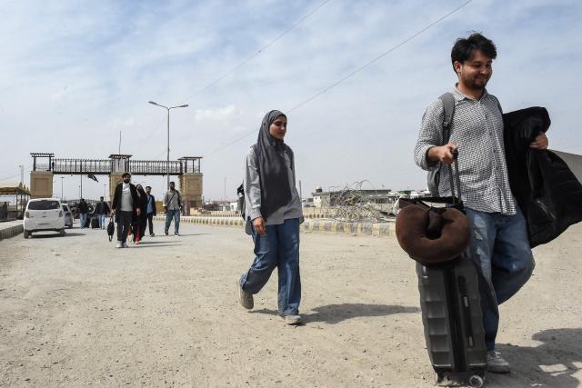 Pakistani nationals walk across the Taftan border after returning from Iran, in Balochistan province, on March 2, 2026 amid ongoing US-Israel strikes on Iran. (Photo by Banaras KHAN / AFP)