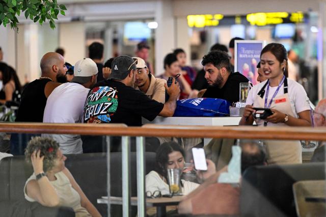 Passengers wait amid flights disruptions as a result of the Israeli-US strikes on Iran, at Ngurah Rai International Airport on Indonesia's resort island of Bali, on March 2, 2026. (Photo by SONNY TUMBELAKA / AFP)