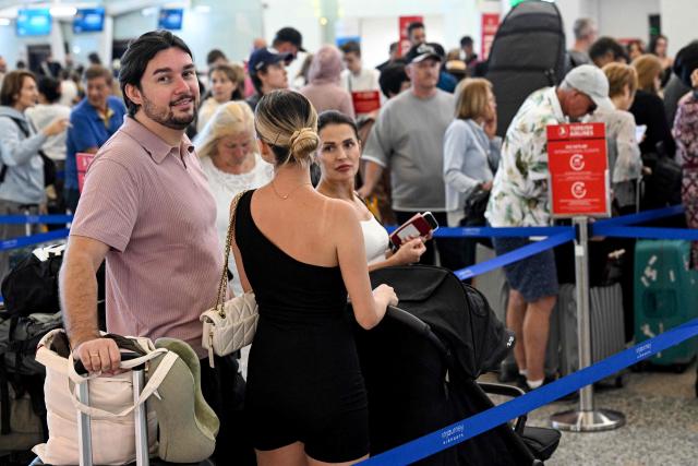 Passengers wait amid flights disruptions as a result of the Israeli-US strikes on Iran, at Ngurah Rai International Airport on Indonesia's resort island of Bali, on March 2, 2026. (Photo by SONNY TUMBELAKA / AFP)