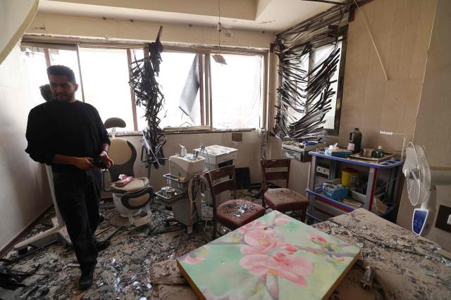 A man looks at the damage inside the Gandi Hospital, which was hit March 1, when a projectile struck a state TV communications tower and nearby buildings across the street, during the ongoing joint US-Israeli military campaign on the capital Tehran on March 2, 2026. The United States and Israel launched strikes against Iran on February 28, killing Iran's supreme leader and top military leaders, prompting authorities to retaliate with strikes on Israel and across the Gulf. (Photo by ATTA KENARE / AFP)