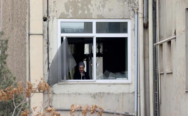 A woman works in the kitchen damaged after the nearby state TV communications tower was targeted on  March 1, when a projectile struck during the ongoing joint US-Israeli military campaign on the capital Tehran on March 2, 2026. The United States and Israel launched strikes against Iran on February 28, killing Iran's supreme leader and top military leaders, prompting authorities to retaliate with strikes on Israel and across the Gulf. (Photo by ATTA KENARE / AFP)