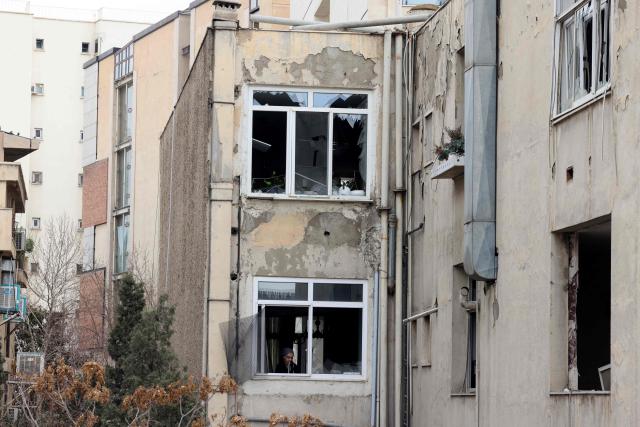 A woman works in the kitchen damaged after the nearby state TV communications tower was targeted on  March 1, when a projectile struck during the ongoing joint US-Israeli military campaign on the capital Tehran on March 2, 2026. The United States and Israel launched strikes against Iran on February 28, killing Iran's supreme leader and top military leaders, prompting authorities to retaliate with strikes on Israel and across the Gulf. (Photo by ATTA KENARE / AFP)