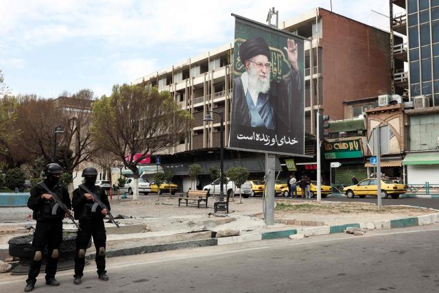 Members of Iranian security forces stand guard on a street next to a billboard of Iran’s supreme leader Ayatollah Ali Khamenei in Tehran on March 2, 2026. Israeli strikes on Lebanon killed at least 31 people on March 2, authorities said, following rocket fire from Tehran-backed militant group Hezbollah after the killing of Iran's supreme leader. (Photo by AFP)