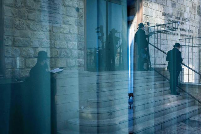 TOPSHOT - Jewsih ultra-Orthodox men pray outside the closed Western Wall in the Old city of Jerusalem on March 2, 2026. The United States and Israel launched strikes against Iran on February 28, with the killing of Iran's supreme leader and the Islamic republic retaliated with barrages of missiles at Gulf states and Israel. (Photo by JOHN WESSELS / AFP)