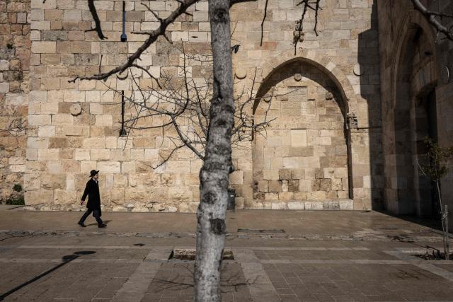 An ultra-Orthodox Jewish man walks down an empty path towards Jaffa Gate, outside the Old city of Jerusalem on March 2, 2026. The United States and Israel launched strikes against Iran on February 28, with the killing of Iran's supreme leader and the Islamic republic retaliated with barrages of missiles at Gulf states and Israel. (Photo by JOHN WESSELS / AFP)