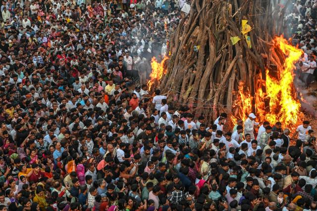 Devotees perform rituals around a sacred fire called 'Holika Dahan' as part of Holi, the Hindu spring festival of colours, at Palaj village in Gandhi Nagar on March 2, 2026. (Photo by Shammi MEHRA / AFP)