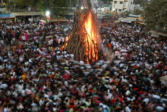 Devotees perform rituals around a sacred fire called 'Holika Dahan' as part of Holi, the Hindu spring festival of colours, at Palaj village in Gandhi Nagar on March 2, 2026. (Photo by Shammi MEHRA / AFP)