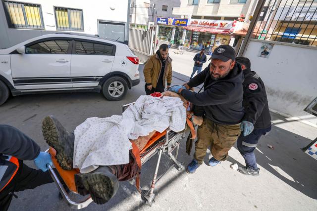 Paramedics and local residents transport the body of Palestinian Faheem Muammar after he was killed by Israeli settlers in the village of Qaryut, to the Rafidia Hospital in the city of Nablus in the Israeli-occupied West bank, on March 2, 2026. Israeli settlers killed two brothers Mohammed and Faheem Muammar in an attack on the occupied West Bank village of Qaryut on March 2, that also left three people including a child injured, the Ramallah-based health ministry and Palestinian Red Crescent said.  Violence in the Palestinian West Bank, which Israel has occupied since 1967, has soared since the Hamas attack on Israel triggered the Gaza war in October 2023. (Photo by JAAFAR ASHTIYEH / AFP)