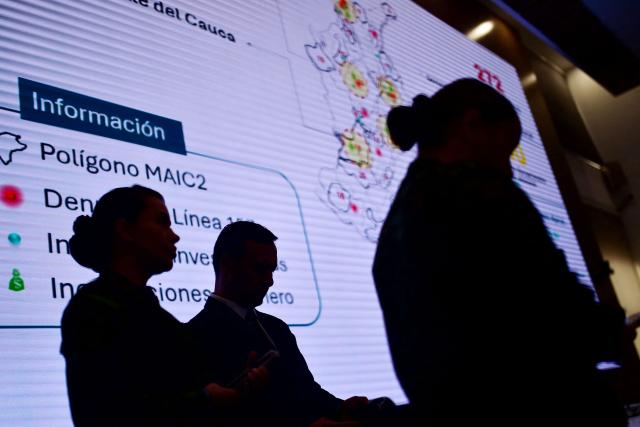 The silhouette of Colombia's Defense Minister, Pedro Arnulfo Sanchez (C), is seen looking at his mobile phone during a press conference to inform about the security measures to be implemented for the next legislative and presidential elections at the National Police headquarters in Bogota on March 2, 2026. Colombia will hold legislative elections on March 8 and presidential elections on May 31. (Photo by Pablo VERA / AFP)