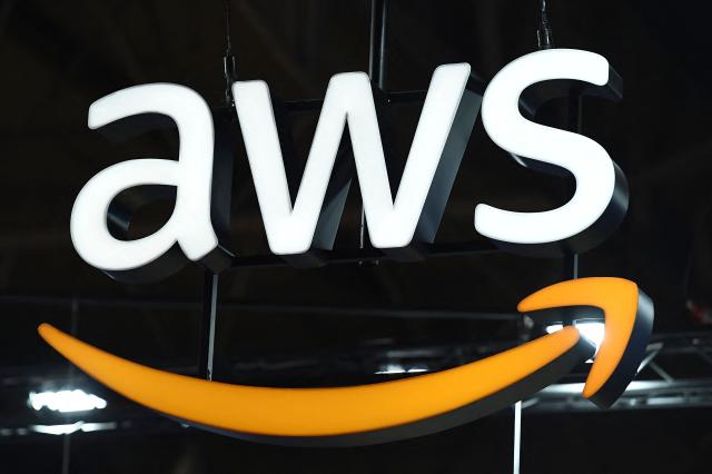 (FILES) The logo of Amazon Web Services AWS is seen on the opening day of the Integrated Systems Europe (ISE) audiovisual and systems integration exhibition in Barcelona on January 31, 2023. Amazon on February 2, 2026 announced another 18 billion euros ($21 billion) of investment in data centre projects in Spain, more than doubling its spending there on the infrastructure crucial for artificial intelligence and cloud computing. (Photo by Pau BARRENA / AFP)
