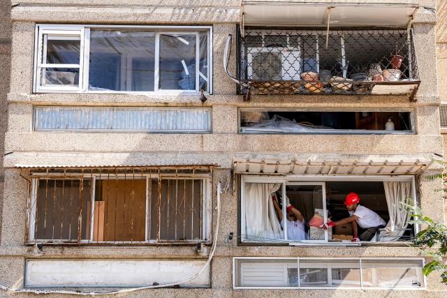 Workers clean up damage from a missile strike a day after an attack killed several people in Bet Shemesh, some 30 kilometres west of Jerusalem in central Israel, on March 2, 2026. A barrage of missiles launched from Iran killed at least six people in Bet Shemesh on March 1, Israel's first responders agency, Magen David Adom (MDA) said, the day after the US and Israel attacked Iran and assassinated its supreme leader. (Photo by Maya Levin / AFP)