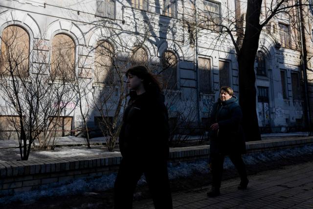 Two women  walk down a street in Kyiv on March 2, 2026, amid the Russian invasion of Ukraine. (Photo by Tetiana DZHAFAROVA / AFP)