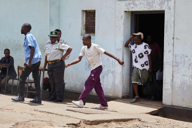 TOPSHOT - Inmates who qualified to be releaased from prison during an amnesty granted by Zimbabwe President Emmerson Mnangagwa walk a step towards freedom on March 2, 2026. Zimbabwe on Monday began releasing nearly 4,000 inmates who were granted presidential amnesty in a bid to ease overcrowding in prisons.
The cabinet announced the amnesty in February on the same day it approved sweeping changes to the constitution as part of a plan to extend 83-year-old President Emmerson Mnangagwa's term till 2030.
"The nation should note that the release of the 3,978 beneficiaries begins today," Justice Minister Ziyambi Ziyambi said at a press conference in the capital Harare.
Zimbabwe's prisons held just over 24,000 inmates in the second quarter of 2025, according to recent available national data. (Photo by Jekesai NJIKIZANA / AFP)
