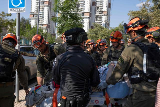 Rescue workers evacuate an elderly woman at the scene of an Iranian missile strike in Beer Sheva on March 2, 2026. The United States and Israel launched strikes against Iran on February 28, killing Iran's supreme leader and top military leaders, prompting authorities to retaliate with strikes on Israel and across the Gulf. (Photo by Maya Levin / AFP)