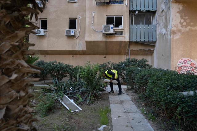 A man collects debris at the scene of an Iranian missile strike in Beersheva on March 2, 2026. The United States and Israel launched strikes against Iran on February 28, killing Iran's supreme leader and top military leaders, prompting authorities to retaliate with strikes on Israel and across the Gulf. (Photo by Maya Levin / AFP)