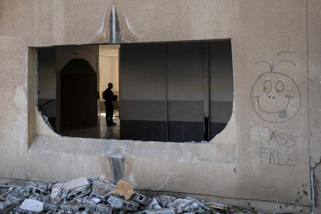 A member of the Israeli security forces stands in a building at the scene of an Iranian missile strike in Beersheva on March 2, 2026. The United States and Israel launched strikes against Iran on February 28, killing Iran's supreme leader and top military leaders, prompting authorities to retaliate with strikes on Israel and across the Gulf. (Photo by Maya Levin / AFP)