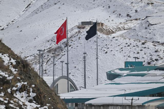 This photograph shows a Turkish national flag (L) at the Razi-Kapikoy border crossing with Iran next to a black flag (R) on the Iranian side, following the death of Iran's supreme leader Ayatollah Ali Khamenei, in the province of Van, eastern Turkey on March 2, 2026. Turkey and Iran have mutually suspended day-trip crossings at their border, Turkey's trade minister said Monday as Israeli-US strikes continued to pound the Islamic Republic. (Photo by Ali IHSAN OZTURK / AFP)