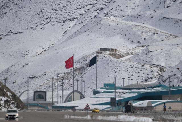 This photograph shows a Turkish national flag (L) at the Razi-Kapikoy border crossing with Iran next to a black flag (R) on the Iranian side, following the death of Iran's supreme leader Ayatollah Ali Khamenei, in the province of Van, eastern Turkey on March 2, 2026. Turkey and Iran have mutually suspended day-trip crossings at their border, Turkey's trade minister said Monday as Israeli-US strikes continued to pound the Islamic Republic. (Photo by Ali IHSAN OZTURK / AFP)