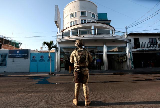 An army soldier stands guard outside La Paz funeral home, during the wake of drug trafficker Nemesio "El Mencho" Oseguera in Guadalajara, Jalisco state, Mexico, on March 2, 2026. Mexican soldiers watched over the funeral of Oseguera, who died on February 22 during a military operation. (Photo by Ulises Ruiz / AFP)