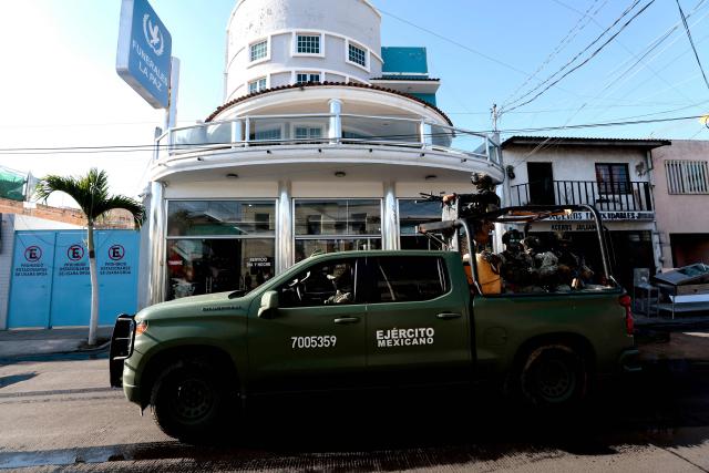 Army soldiers patrol outside La Paz funeral home, during the wake of drug trafficker Nemesio "El Mencho" Oseguera in Guadalajara, Jalisco state, Mexico, on March 2, 2026. Mexican soldiers watched over the funeral of Oseguera, who died on February 22 during a military operation. (Photo by Ulises Ruiz / AFP)