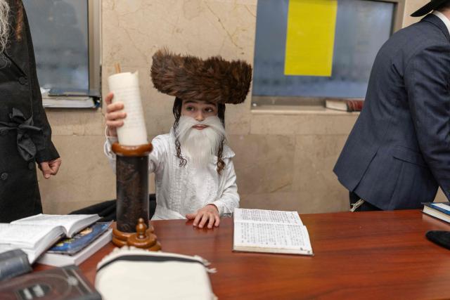 An ultra-Orthodox Jewish child sits in a Yeshiva as he celebrates the carnival-like Purim holiday in Bnei-Brak on March 2, 2026. The United States and Israel launched strikes against Iran on February 28, killing Iran's supreme leader and top military leaders, prompting authorities to retaliate with strikes on Israel and across the Gulf. (Photo by Ilia YEFIMOVICH / AFP)