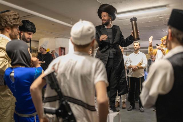Israelis gather in a parking lot used as a shelter to celebrate the carnival-like Purim holiday in Tel-aviv on March 2, 2026. The United States and Israel launched strikes against Iran on February 28, killing Iran's supreme leader and top military leaders, prompting authorities to retaliate with strikes on Israel and across the Gulf. (Photo by Ilia YEFIMOVICH / AFP)