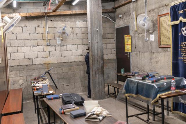 An ultra-Orthodox Jewish man stand behind a pillar at a Yeshiva during Purim celebrations in Bnei-Brak on March 2, 2026. The United States and Israel launched strikes against Iran on February 28, killing Iran's supreme leader and top military leaders, prompting authorities to retaliate with strikes on Israel and across the Gulf. (Photo by Ilia YEFIMOVICH / AFP)