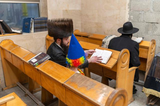 Ultra-Orthodox Jews sit in a Yeshiva as they celebrate the carnival-like Purim holiday in Bnei-Brak on March 2, 2026. The United States and Israel launched strikes against Iran on February 28, killing Iran's supreme leader and top military leaders, prompting authorities to retaliate with strikes on Israel and across the Gulf. (Photo by Ilia YEFIMOVICH / AFP)