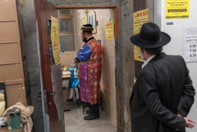 Ultra-Orthodox Jews gather in a Yeshiva as they celebrate the carnival-like Purim holiday in Bnei-Brak on March 2, 2026. The United States and Israel launched strikes against Iran on February 28, killing Iran's supreme leader and top military leaders, prompting authorities to retaliate with strikes on Israel and across the Gulf. (Photo by Ilia YEFIMOVICH / AFP)