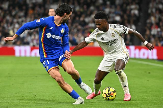 Getafe's Spanish defender #21 Juan Iglesias and Real Madrid's Brazilian forward #07 Vinicius Junior fight for the ball during the Spanish league football match between Real Madrid CF and Getafe CF at Santiago Bernabeu Stadium in Madrid on March 2, 2026. (Photo by Javier SORIANO / AFP)