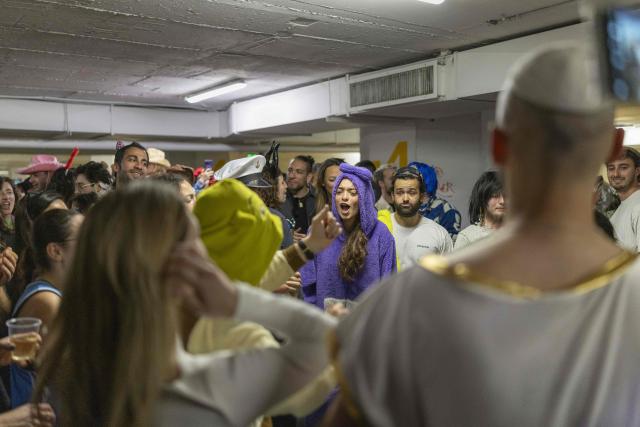 Israelis dressed in costumes gather in a parking lot used as a shelter to celebrate the carnival-like Purim holiday in Tel-Aviv on March 2, 2026. The United States and Israel launched strikes against Iran on February 28, killing Iran's supreme leader and top military leaders, prompting authorities to retaliate with strikes on Israel and across the Gulf. (Photo by Ilia YEFIMOVICH / AFP)