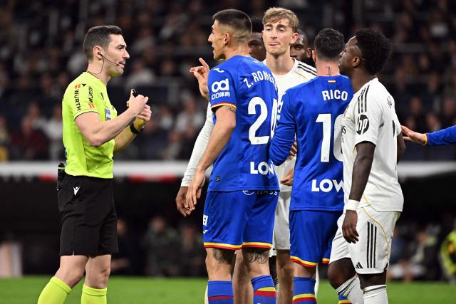 Spanish referee Muniz Ruiz speaks with Getafe's Argentine defender #24 Zaid Romero during the Spanish league football match between Real Madrid CF and Getafe CF at Santiago Bernabeu Stadium in Madrid on March 2, 2026. (Photo by Javier SORIANO / AFP)