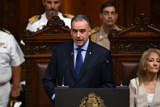 Uruguay's President Yamandu Orsi delivers a speech before the General Assembly next to Uruguay's Vice President Carolina Cosse (R) at the Legislative Palace in Montevideo on March 2, 2026, marking his first year in office. (Photo by EITAN ABRAMOVICH / AFP)