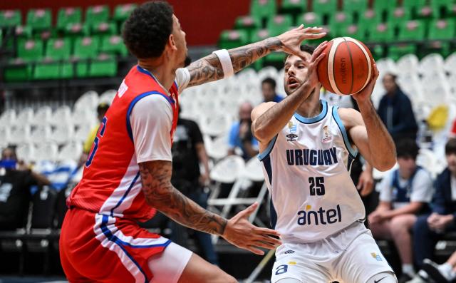 Uruguay's Santiago Vescovi (R) dribbles against Cuba's Pedro Bombino during the FIBA Basketball World Cup 2027 Americas qualifiers match between Cuba and Uruguay at the Arena Roberto Duran in Panama City on March 2,2026. (Photo by MARTIN BERNETTI / AFP)