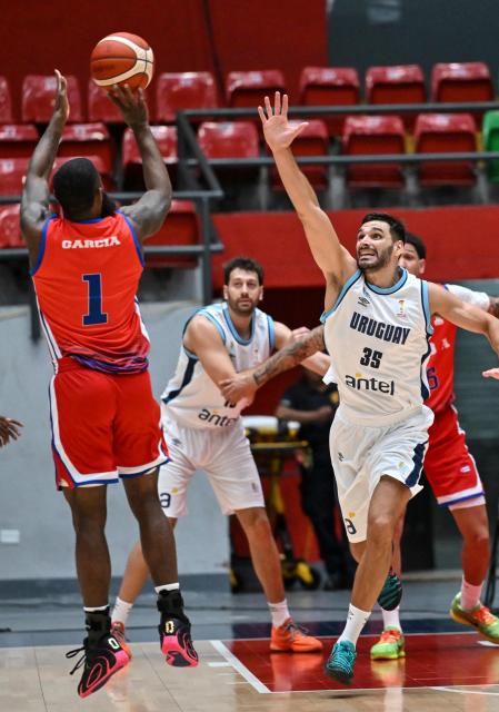 Uruguay's Gonzalo Iglesias (R) attempts to block Cuba's Reynaldo Garcia during the FIBA Basketball World Cup 2027 Americas qualifiers match between Cuba and Uruguay at the Arena Roberto Duran in Panama City on March 2,2026. (Photo by MARTIN BERNETTI / AFP)