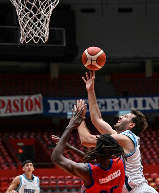 Uruguay's Emiliano Serres (R) takes a shot past Cuba's Ibrahin Hechavarria during the FIBA Basketball World Cup 2027 Americas qualifiers match between Cuba and Uruguay at the Arena Roberto Duran in Panama City on March 2,2026. (Photo by MARTIN BERNETTI / AFP)