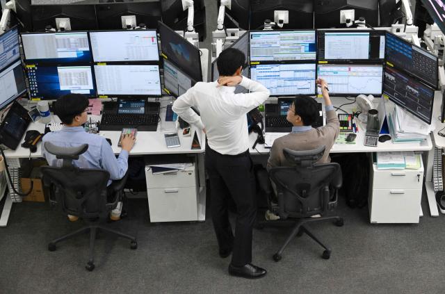 Currency dealers monitor exchange rates in a foreign exchange dealing room at the Hana Bank headquarters in Seoul on March 3, 2026. (Photo by Jung Yeon-je / AFP)