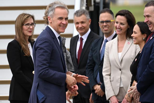 Canada's Prime Minister Mark Carney is welcomed by officials upon his arrival at Sydney Airport on March 3, 2026. (Photo by Saeed KHAN / AFP)