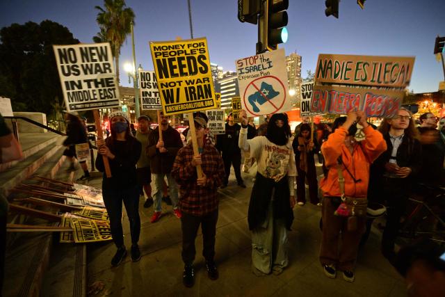 Demonstrators hold placards as they rally during a protest against military action in Iran outside of City Hall in Los Angeles, California, on March 2, 2026. New strikes were reported on March 2 across the Middle East, including Israeli strikes on Lebanon and a drone attack on the US embassy in Saudi Arabia's capital Riyadh. The conflict started by US and Israeli strikes on Iran over the weekend, which sparked retaliatory Iranian attacks across the region, showed no sign of abating as it entered its fourth day. (Photo by Frederic J. Brown / AFP)