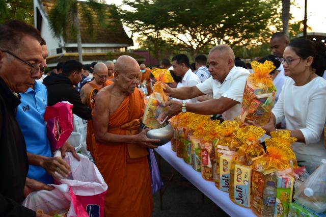 Buddhist devotees offer food to monks during an event to mark Makha Bucha Day in the southern Thai town of Narathiwat on March 3, 2026. (Photo by Madaree TOHLALA / AFP)
