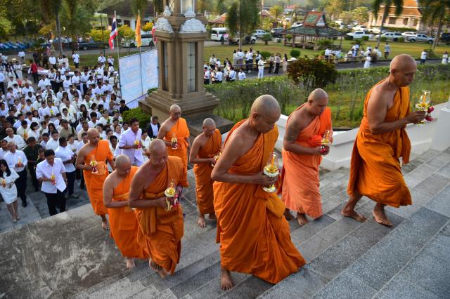 Buddhist monks walk up steps to a giant Buddha statue during an event to mark Makha Bucha Day in the southern Thai town of Narathiwat on March 3, 2026. (Photo by Madaree TOHLALA / AFP)