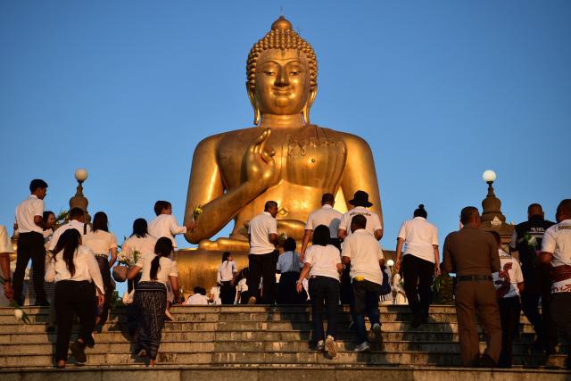 TOPSHOT - Buddhist devotees walk up to a giant Buddha statue during an event to mark Makha Bucha Day in the southern Thai town of Narathiwat on March 3, 2026. (Photo by Madaree TOHLALA / AFP)
