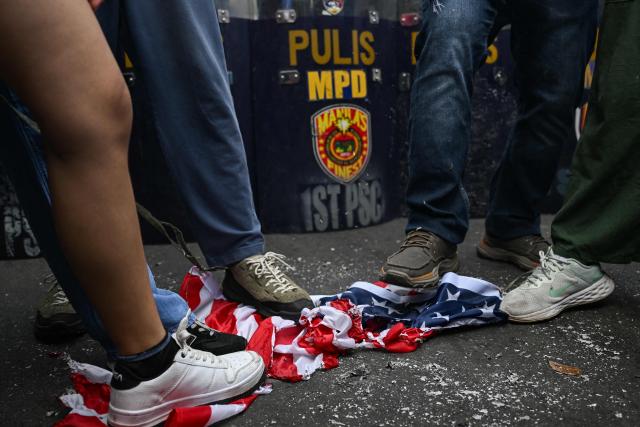 Activists step on a US flag during a rally condemning the US-Israeli strikes on Iran, near the US embassy in Manila on March 3, 2026. (Photo by Jam STA ROSA / AFP)
