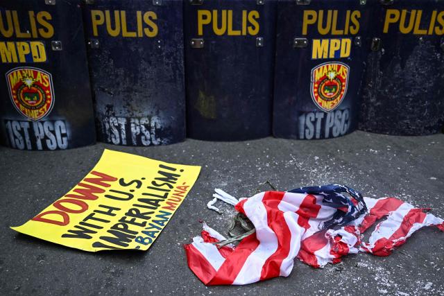 Activists burn a US flag during a rally condemning the US-Israeli strikes on Iran, near the US embassy in Manila on March 3, 2026. (Photo by Jam STA ROSA / AFP)