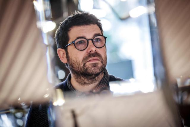 French illustrator and writer Mathieu Persan poses during a photo session in Paris on February 25, 2026. "How is it that on a starry night, she sees nothing but infinite darkness?" wonders illustrator Mathieu Persan in a powerful graphic novel, "Le Passage", which recounts his 15-year-old daughter's deep depression and pays tribute to the many children in France who "are not doing well". On the cover, two small figures walk under a starry sky towards a distant point of light. Published on March 11, 2026 by Hachette, it is a story without pathos, in which the voice of a teenage girl responds to that of her father, a graphic novel with minimalist black and white illustrations, full of fantasy and humour, despite its serious subject matter. (Photo by STEPHANE DE SAKUTIN / AFP)